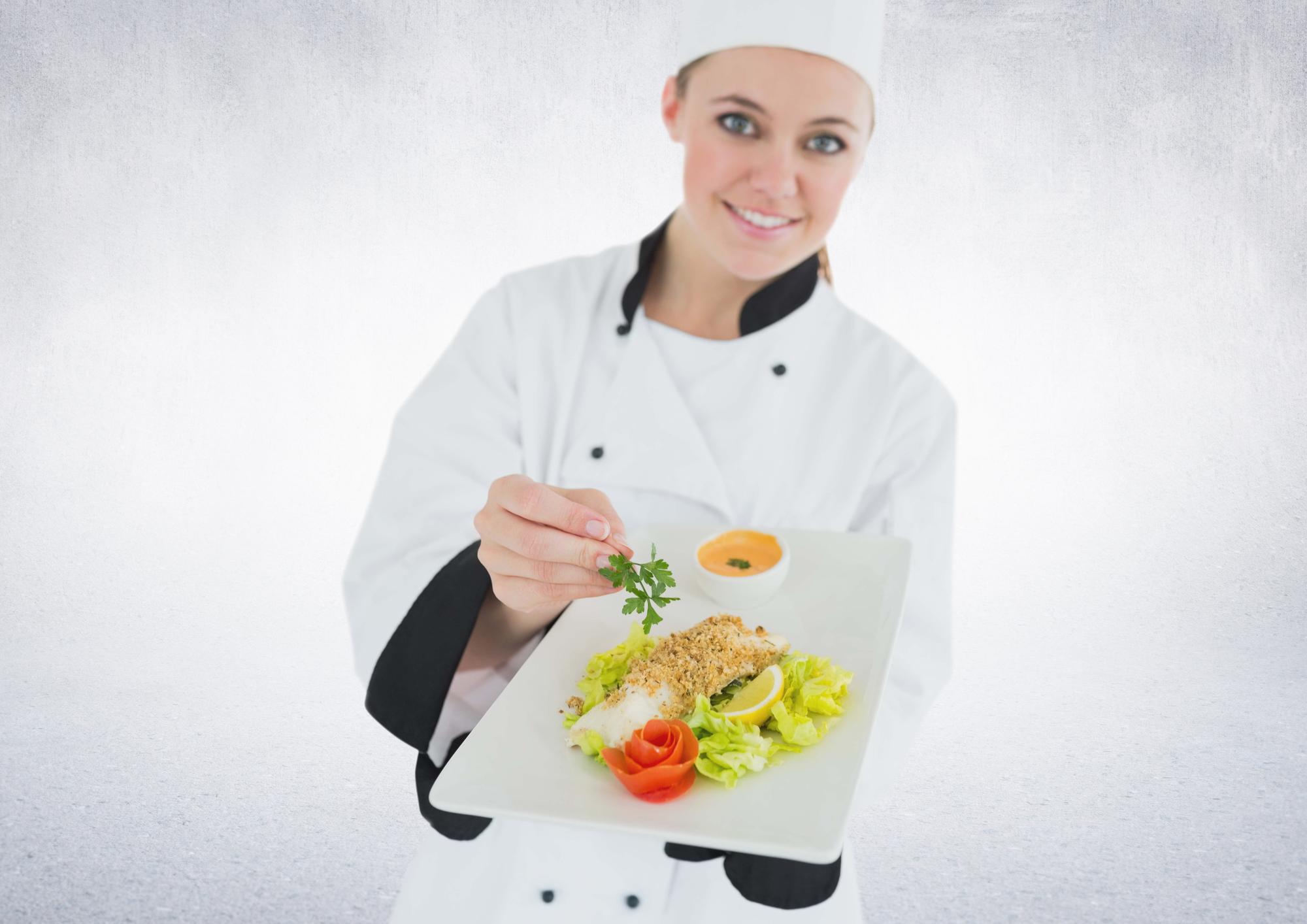 Chef sorridente che mostra un piatto colorato